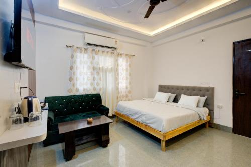 a bedroom with a bed and a couch at Amara Inn by Sandane Homes Near Expo mart and Pari Chowk in Greater Noida