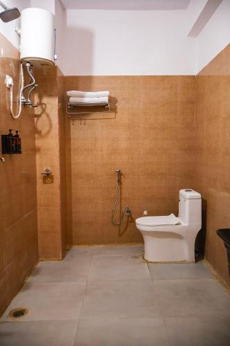 a bathroom with a toilet and a shower at Amara Inn by Sandane Homes Near Expo mart and Pari Chowk in Greater Noida