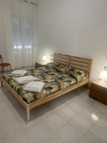 a bedroom with a wooden bed with two tables and a window at Casa Vacanze Nautilus in Termoli