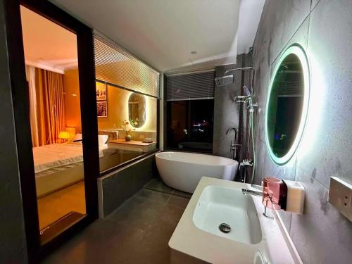 a bathroom with a tub and a sink and a mirror at Huong Sky Co To in Chung Cap