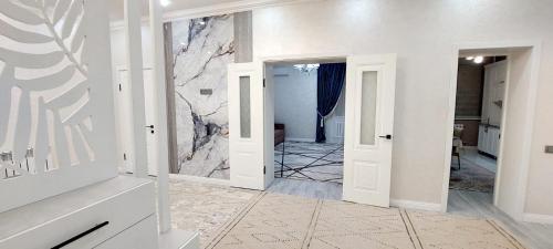 a hallway with white walls and a marble wall at Яншина 2 in Qyzylorda