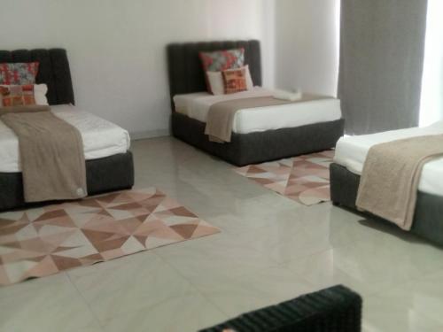 a room with three beds and a tiled floor at Natisa Lodge in Livingstone