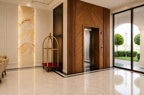 a lobby with a door and a luggage cart on the floor at Amanat Prestige Hotel in Samarkand