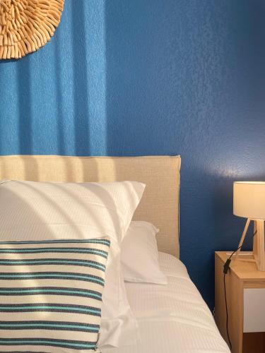 a bedroom with a blue wall and a bed with a pillow at Hotel Port Marine in Sète