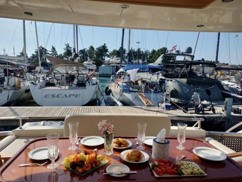 a table with food on top of a boat with boats at Houseboat Dolce Vita in Novigrad Istria