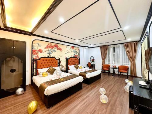 a hotel room with two beds and a desk at Vera Luxury Hotel in Hanoi