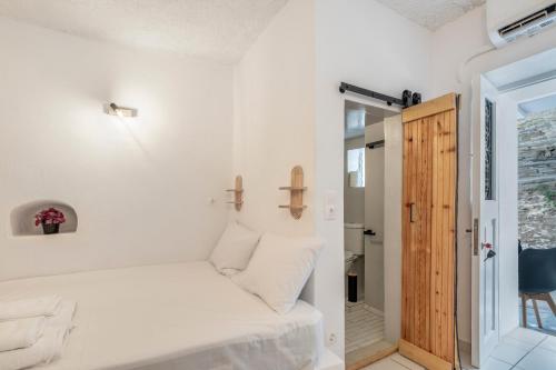 a small bedroom with a bed and a door at Bougainvillea in Andros