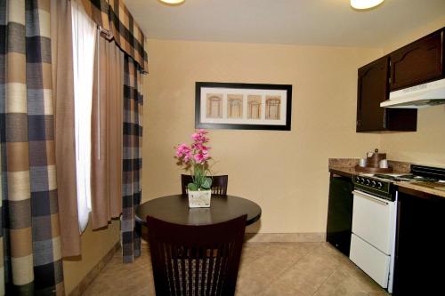 
a kitchen with a table and chairs and a refrigerator at Best Western Plus Las Vegas West in Las Vegas
