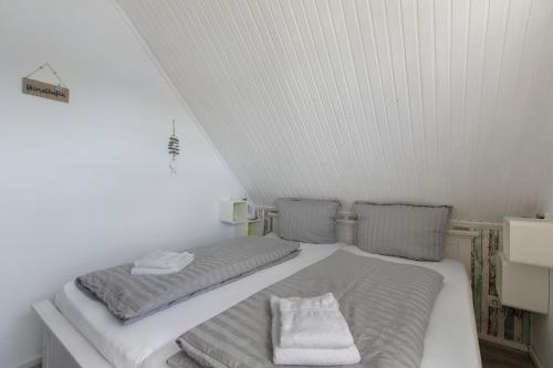 a small bedroom with two beds in a attic at Fewo Küstkieker in Böhl
