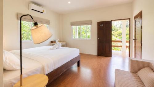 a bedroom with a bed and a sliding glass door at Zen Village in Ko Phangan