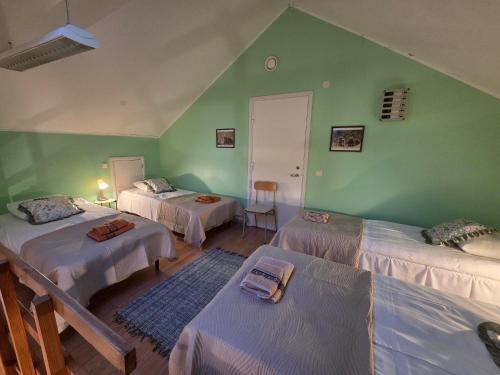 a room with three beds and a green wall at Lodja Jäägrimaja in Lodja
