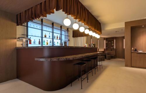 a bar in a hotel with stools in a room at Hotel Medium Montecarlo in Llafranc