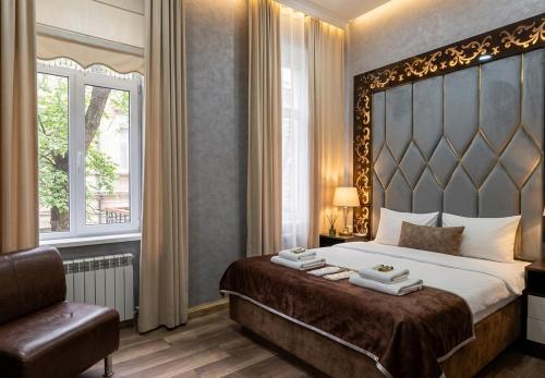 a bedroom with a large bed and a window at Baku City Inn Boutique Nizami Hotel in Baku