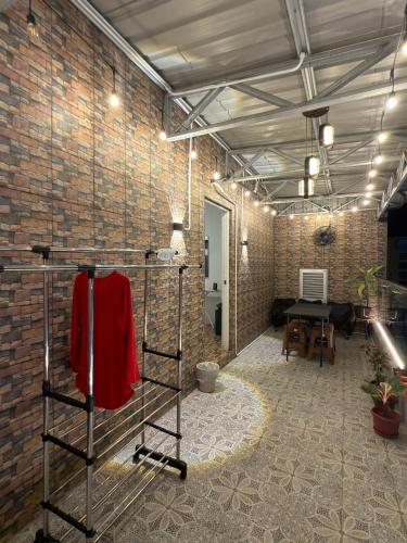 a room with a brick wall and a red shirt on a rack at OR Stay Semporna in Semporna