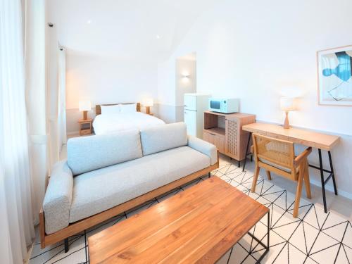 a living room with a couch and a bed at Pricia Resort Yoron in Yoron