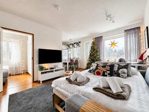 a bedroom with a large bed with a christmas tree at Adorable Arctic Apartments - Private Sauna & Free Parking in Rovaniemi