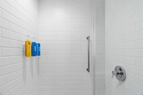 a bathroom with a shower with two blue bottles at Tru By Hilton Valparaiso in Valparaiso
