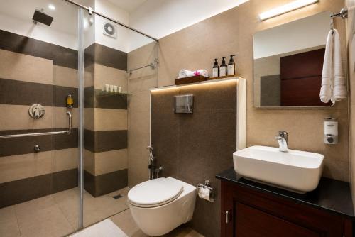 a bathroom with a toilet and a sink and a shower at Pleasant Hill Resort - Munnar in Munnar