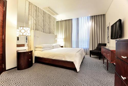 a hotel room with a bed and a television at DAVINCI Suites in Johannesburg