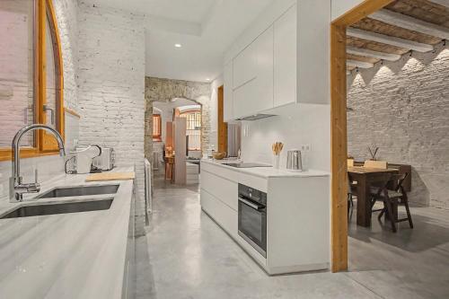 a kitchen with white appliances and a dining room at Casa Elegante in Vilanova i la Geltrú