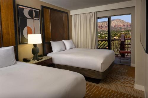 a hotel room with two beds and a balcony at Hilton Sedona Resort at Bell Rock in Sedona