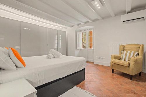 a bedroom with a bed and a chair at Casa Elegante in Vilanova i la Geltrú
