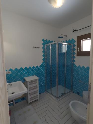 a bathroom with a shower and a sink and a toilet at La Corte Degli Ulivi Appartamenti in Cala Liberotto