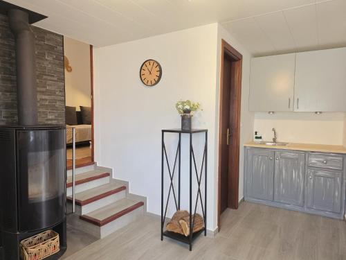 a living room with a staircase and a clock on the wall at Refúgio do Zé Espanhol in Arcos de Valdevez