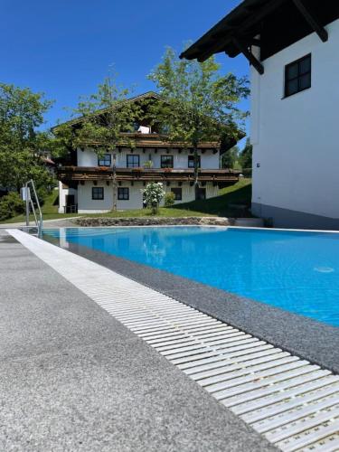 a swimming pool in front of a house at Feriendorf Hauzenberg-Pool&Sauna in Hauzenberg