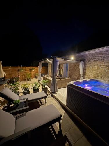 a patio with a swimming pool at night at Dalmatian Stone House Angela in Drniš