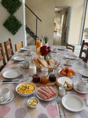 a table with breakfast foods and drinks on it at Gîte Chez Claudia in Marsolan