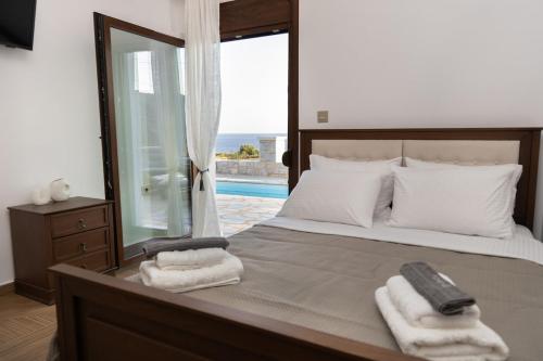 a bedroom with a large bed with towels on it at Vakontas Luxury Stay in Gerolimenas