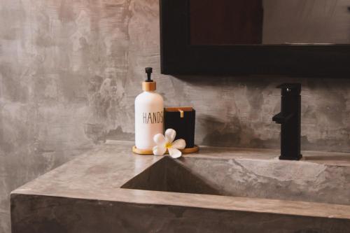 a bottle of shampoo sitting on a bathroom sink at Seagreen Guesthouse - Galle Fort in Galle
