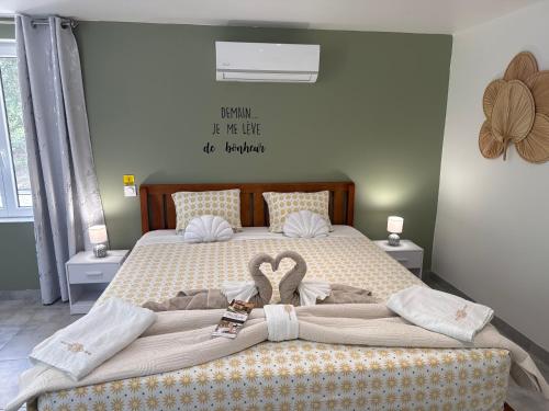 a large bed with a heart made out of blankets at Gîte Chez Claudia in Marsolan