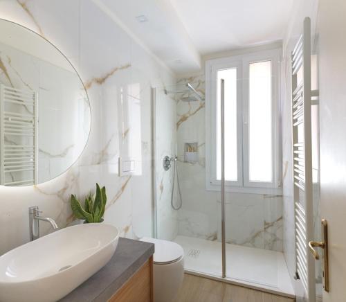a white bathroom with a tub and a sink at Ca del Mar Venice Luxury Apartments in Venice