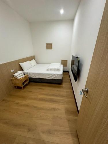 a small room with a bed and a television at 滸衖海旅 in Anping