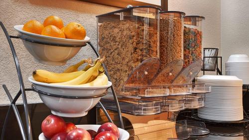 a table with bowls of fruit and plates of food at Days Inn by Wyndham Indiana Benjamin Franklin Highway in Indiana