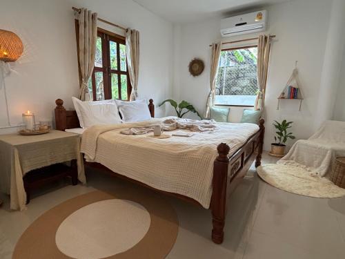 a bedroom with a large bed and a window at Thong Sala Japandi Villa in Thong Sala