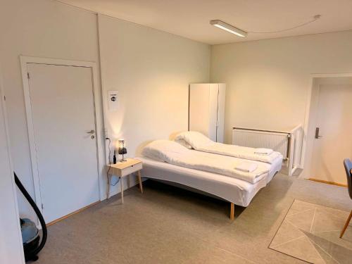 a small room with a bed and a table at Ilulissat Harbour Stay in Ilulissat