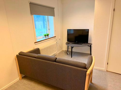 a living room with a couch and a television at Ilulissat Harbour Stay in Ilulissat