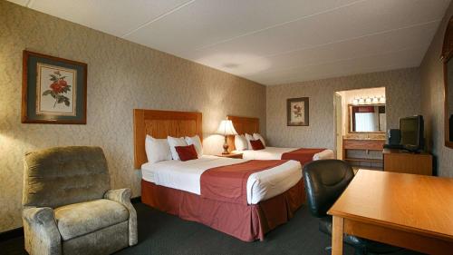 een hotelkamer met 2 bedden, een bureau en een stoel bij Best Western Wilderness Trail Inn in Barbourville