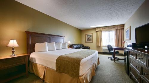 a hotel room with a bed and a desk and a television at Best Western Shelbyville Lodge in Shelbyville