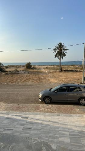 a car parked on the side of a road near the beach at Ninou diamants in Harqalah