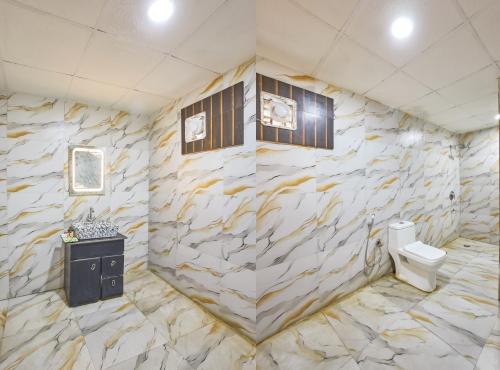 a bathroom with a stone wall with a toilet at Hotel Anand - Near Ganga Ram & BLK Hospital At Karol Bagh Metro Station in New Delhi