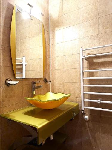 a bathroom with a yellow sink and a mirror at Villa Maria Revas in Sunny Beach