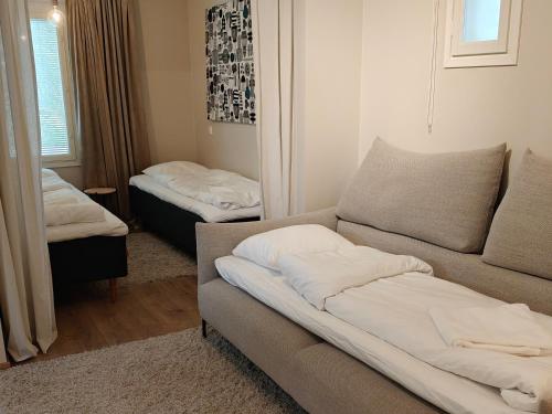 a living room with a couch and two beds at Metsäniitty in Kempele