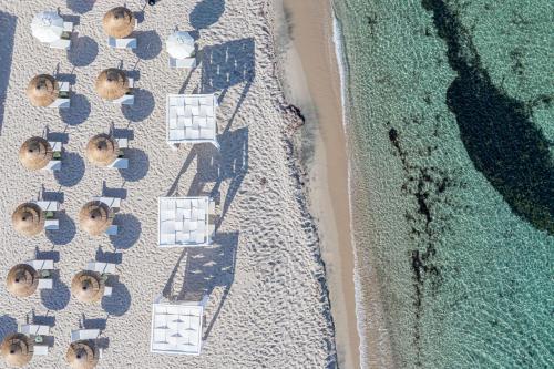 an overhead view of a beach with umbrellas and the ocean at Bellevue Sardinia Resort, Affiliated by Meliá in Valledoria