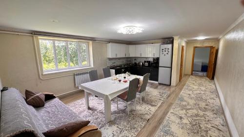 a living room with a table and a kitchen at NomadicaKyrgyz in Tërt-Kul'