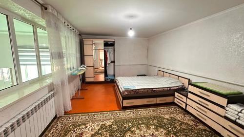 a bedroom with a bed and a window and a rug at NomadicaKyrgyz in Tërt-Kul'