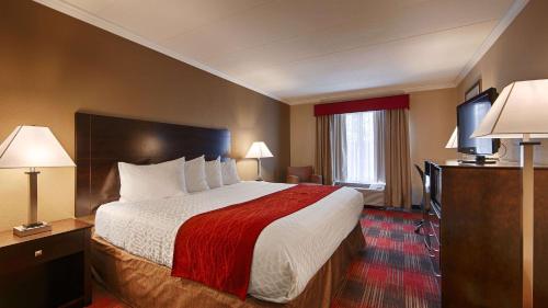 um quarto de hotel com uma cama grande e duas lâmpadas em Best Western Springfield West Inn em West Springfield